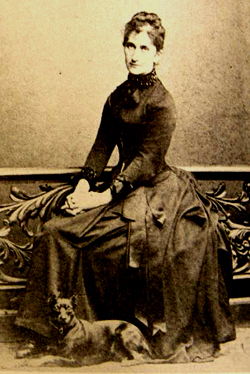 Sepia photograph of Marion von Weber, seated, with a dog at her feet.